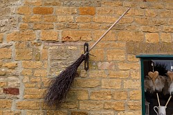 a broom on the honey-coloured wall